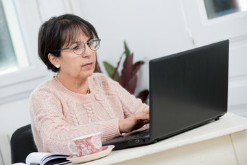 beautiful middle age woman using laptop in home