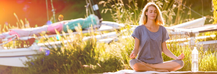 beautiful woman meditating on pontoon sunset © eric