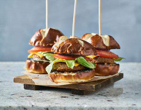 three vegan burger sliders with pretzel buns