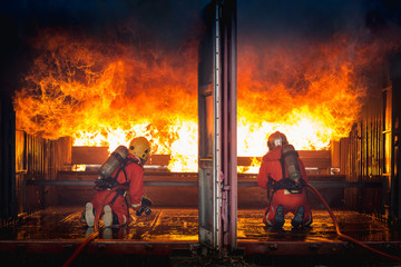 Firefighters training, Team practice to fighting with fire in emergency situation..Spray water to the flame in closed location