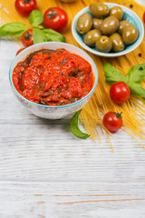 Ingredients for preparation pasta spaghetti - tomato, olive oil, spices, herbs, green olives, tomato sauce