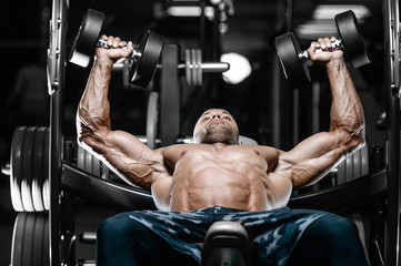 Brutal strong bodybuilder athletic men pumping up muscles with dumbbells.