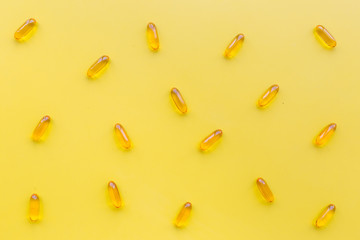 Color capsules. Medicine pills on yellow background top view pattern