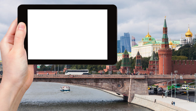 tourist photographs bridge and Kremlin in Moscow