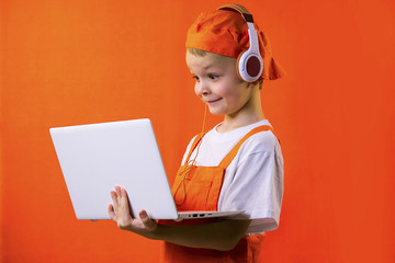 funny boy builder in headphones and laptop doing repairs on bright background