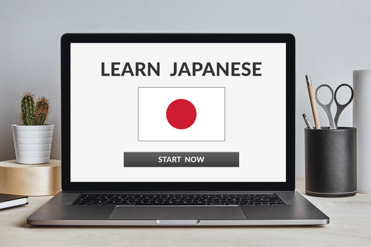 Learn Japanese concept on laptop screen on modern desk. All screen content is designed by me. Front view.
