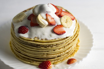 Pancakes with strawberries, bananas and yogurt
