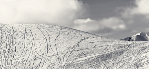 Panoramic view on slope for freeriding with traces from skis, snowboards
