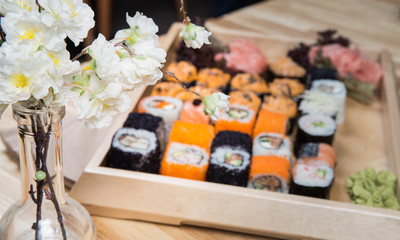 Big sushi and roll set with wasabi on wooden tray