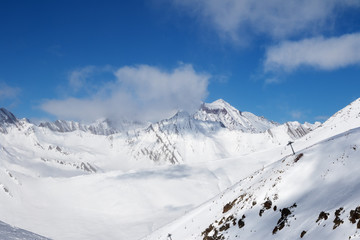 Fototapeta na wymiar Off-piste slope and chair-lift on ski resort at sun day