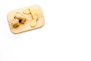 Fresh ginger root on cutting board on white background top view copy space
