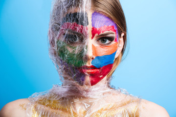 Young attractive girl with face art make-up and plastic wrap