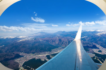 Travel concept with aerial panoramic view of the Carphatian mountain chain peaks from the airplane window