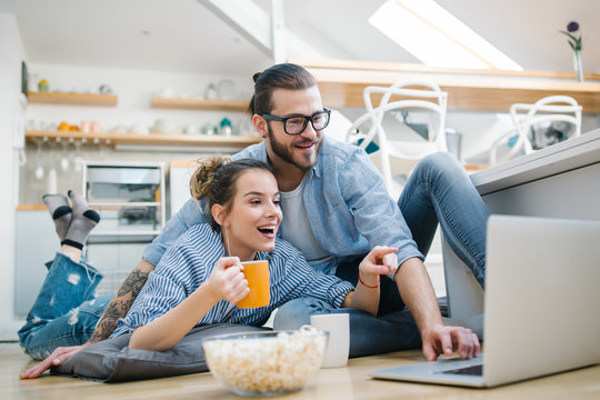 Young Couple Watching Movie On Laptop At Home 