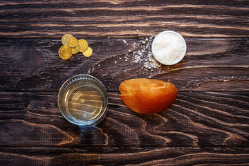 A glass of water and a piece of bread on the table in front of the folded wrinkled hands of a retired old man. Poverty and the problems of retirees of social security.