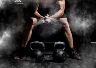  Gewichtheffer klapt in de handen en bereidt zich voor op training in een sportschool © Andrey Burmakin