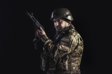 The volunteer on black background with guns and a walkie-talkie