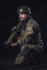 The volunteer on black background with guns and a walkie-talkie