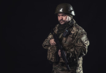 Fototapeta premium The volunteer on black background with guns and a walkie-talkie
