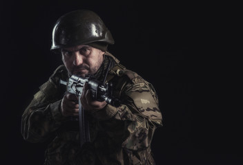 The volunteer on black background with guns and a walkie-talkie