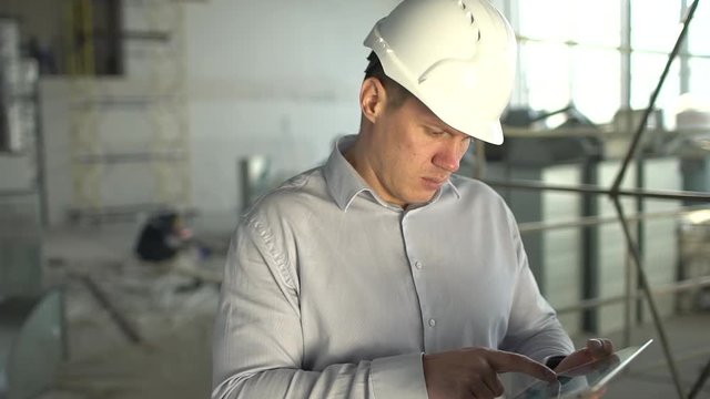 construction engineer with the tablet. pictures of the construction site
