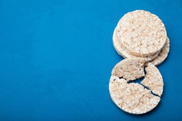 Rice gluten free diet snack on a blue background. Copy space.