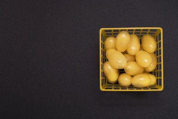 Square yellow grid box with yellow tomatoes on black background © Ruslan Zagidullin