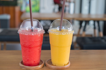 Sweet yellow mango with water melon smoothie on wood table in coffee shop