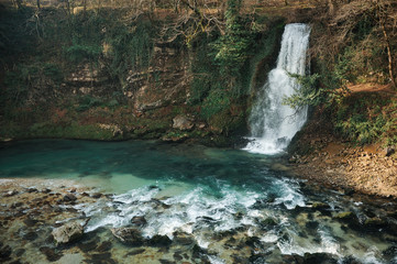 Beautiful flowing mountain waterfall and blue lake in Georgia. Okatse canyon. Martvili canyon