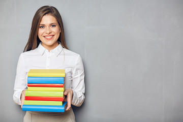 Smiling student girl holding pile books.