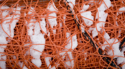 Texture: red (orange) security net, put to the edges of ski slopes as for safety in case of danger, used to prevent falls, accidents or ski patrol, protection for skier, Piedmont, Italy