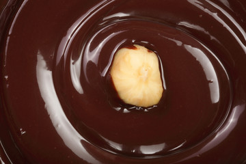 Melted chocolate swirl with hazelnut as a background closeup