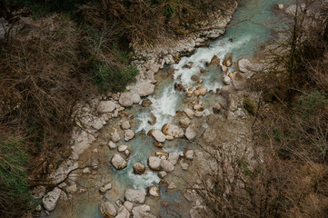 Top view of a powerful blue river stream flowing in forest