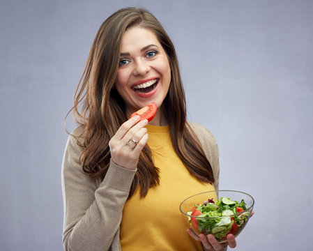 Young woman with long hair eating salad, healthy food.