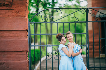 Dazzling bridesmaids walk smiling along the path