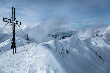 Gipfelkreuz mit Grad im Hintergrund im Winter