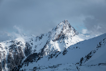 Fototapeta na wymiar Gipfel leuchtet im Gebirge mit Schnee im Winter