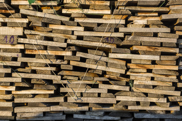 Holzstapel aus ordentlich aufgeschichtetem Scheitholz und Brettern zum trocknen für Kaminholz, Brennholz, Rohstoff, Holzmiete