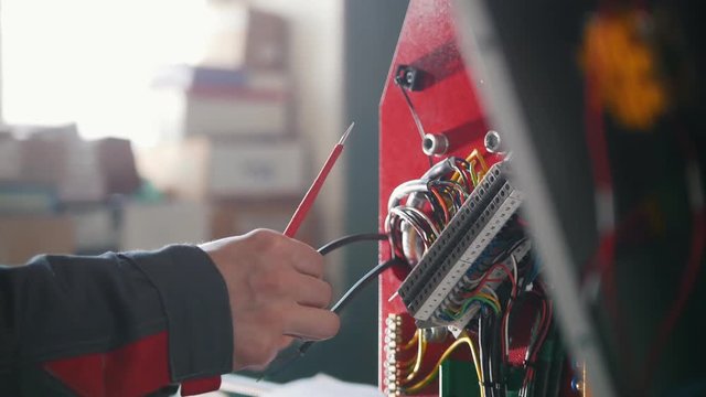 Electrician's hands installing energy system on machinery industry