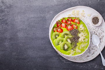 Breakfast Detox Green Smoothie  Bowl with fresh berries,kiwi and chia seeds. Food or Healthy diet concept on the gray background.Super Food.selective focus.