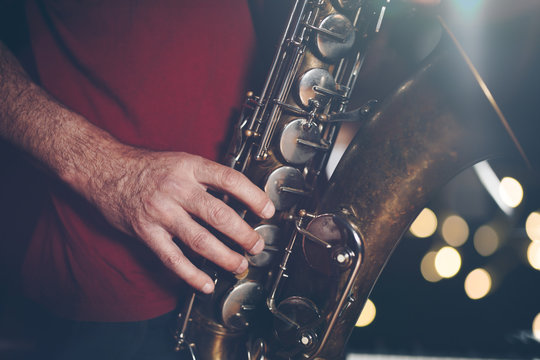 Close up shot of musician playing saxophone. Low light and selective focus.