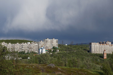 The urban landscape of the Murmansk Soviet architecture and the bright foliage of summer.