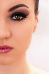 Beautiful young model with professional make up, close up shot on the white background