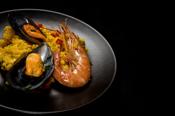 Traditional rice in paella with fish and meat.
