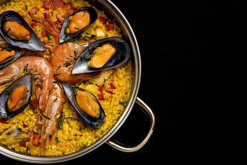 Traditional rice in paella with fish and meat.