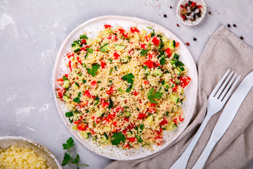 Tabbouleh salad with couscous on the plate.Traditional middle eastern or arab dish.Vegetarian.Parsley,pepper,cucumber,tomato,lemon.Middle eastern meze.Food or Healthy diet concept.Copy space for Text.