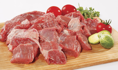 fresh raw red cubed meat chunk on wooden cut board isolated over white background
