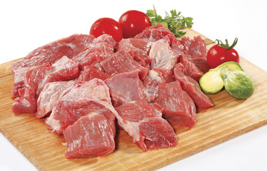 fresh raw red cubed meat chunk on wooden cut board isolated over white background
