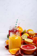 Naklejka na ściany i meble Juices Fresh Orange and Citrus on a White Background.Healthy Beverage.Food or Healthy diet concept.Mixed Colorful Tropical Background.Copy space for Text. selective focus