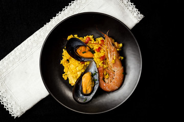 Traditional rice in paella with fish and meat.